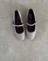 Ballerinas estilo Mary Jane marca Lucy in the Sky, confeccionadas en terciopelo color beige con ribetes y forro interior en color marrón oscuro. Presentan una tira ajustable con hebilla metálica sobre el empeine.