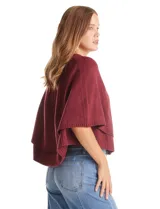 Capa de punto color bordó con diseño envolvente de doble capa superpuesta. Presenta cuello a la base, cierre frontal con botones y mangas estilo japonés con terminaciones acanaladas.