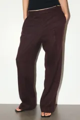 Pantalón sastrero de tiro alto en sarga de mezcla de lino y lyocell, color bordó, con piernas rectas, pliegues delanteros y traseros, bolsillos al bies y presillas para cinto.