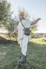 Cartera tipo bombonera pequeña de cuero gamuzado color chocolate, con correa larga regulable de cuero graneado y ajuste superior fruncido.