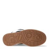 Championes de estilo urbano con diseño bicolor en negro y blanco, confeccionados en material tipo gamuza con cordones anchos blancos y suela de goma color caramelo.
