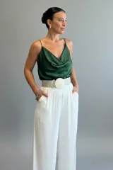Musculosa de satén con escote drapeado tipo buche y breteles finos ajustables. Presenta un diseño fluido y elegante con acabado brillante.