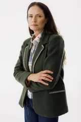 Blazer color verde oscuro con solapas con pespuntes blancos, de corte recto y cierre con un botón.