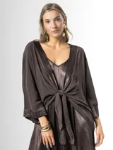 Kimono confeccionado en tejido liviano color marrón chocolate, con bordes satinados y mangas amplias. Puede usarse abierto o cerrado mediante un nudo al frente.