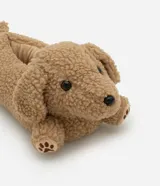 Pantufla cerrada de diseño divertido con forma de perro, confeccionada en tejido de poliéster tipo peluche color tostado, con detalles bordados de huellas en las patas.