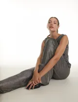 Pantalón modelo palazzo de tiro alto con pretina ancha elastizada, confeccionado en tejido metalizado con textura acanalada.