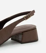 Tacones slingback Satinato en color marrón con textura crocco, puntera fina, taco bloque mediano y tira ajustable con hebilla en el talón.