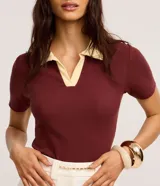 Blusa de manga corta confeccionada en tejido acanalado de algodón con elastano, de color bordó con cuello polo en tono amarillo claro y escote en V.