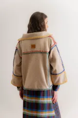 Chaqueta gris de paño de lana con detalles de crochet rojo, corte cuadrado y cuello camisero.