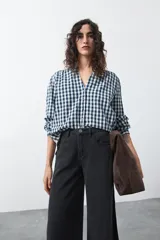 Camisa de algodón con estampado de cuadros vichy en tonos azul y blanco. Presenta escote en V con cierre frontal de botones, mangas largas con puños y un corte levemente holgado con frunces en hombros y espalda.