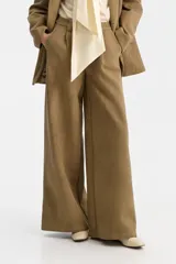 Pantalón sastrero de tiro alto, color verde oliva, de corte ancho y pierna recta. Presenta pliegues frontales y bolsillos funcionales.