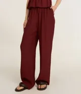 Pantalón recto de viscosa color bordó, con superficie texturizada y lazo ajustable en la cintura.