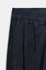 Pantalón chino de tiro medio confeccionado en denim oscuro. Presenta pinzas en el delantero, bolsillos laterales y bajo con acabado en vuelta. Cierre frontal con cremallera y botón.