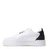 Championes urbanos Puma modelo Shuffle Downtown, de color negro con detalles en dorado. Presentan una capellada de cuero sintético con perforaciones en la puntera, cierre de cordones y suela de goma vulcanizada con tecnología SoftFoam+ para mayor amortiguación.