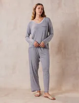 Conjunto de pijama marca René Rofé, compuesto por pantalón y remera a rayas grises y blancas. La remera es de escote en V, con bolsillo en el pecho y mangas largas. El pantalón tiene cintura elastizada y bolsillos laterales.