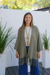 Saco abierto de tejido de punto en color verde oliva, con mangas tres cuartos y detalle de flecos en el ruedo.