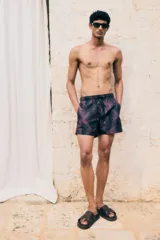 Short de baño con estampado de hojas en tonos oscuros, cuenta con cintura elástica con cordón ajustable, bolsillos laterales y un bolsillo trasero. Incluye suspensor interior de malla.
