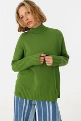 Sweater verde de tejido de punto con cuello alto.