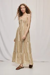Vestido largo negro de algodón, con breteles finos, escote con frunce y lazo regulable. Tiene cintura definida y falda amplia escalonada, con detalles bordados verticales en contraste.