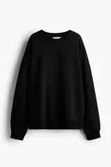 Buzo negro de corte oversized con cuello redondo, hombros caídos y ribetes acanalados en el cuello, puños y bajo.