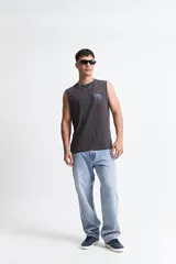 Musculosa de corte oversize color marrón, con escote redondo y estampa gráfica pequeña en el pecho.