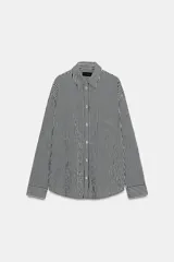 Camisa de corte fluido confeccionada en mezcla de viscosa, con diseño de rayas verticales en blanco y negro. Presenta cuello solapa, manga larga con puños, bolsillo de plastrón en el pecho, bajo redondeado y cierre frontal con botones.