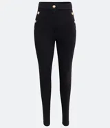 Pantalón legging negro de punto roma, con cintura alta y botones metalizados decorativos en los laterales.