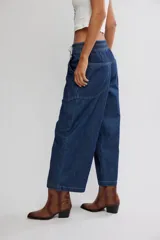 Jean azul de tiro medio con cintura elástica ajustable mediante cordón, bolsillos plaqué delanteros y diseño de pernera ancha y holgada.