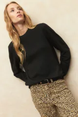 Polera color borgoña de tejido de punto con cuello alto y mangas largas.