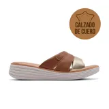 Sandalia tipo chinela con plataforma baja, confeccionada en cuero con tiras cruzadas en tonos marrón texturizado y dorado. Presenta un aplique metálico decorativo en el lateral y suela de goma con relieve.