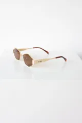 Lentes de sol con armazón y patillas metálicas doradas, diseño de forma geométrica hexagonal y cristales oscuros con protección UV400.