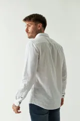 Camisa de manga larga color rosa claro con pequeños lunares azules, confeccionada en lino y algodón, de corte regular y logo bordado.