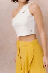Top corto de diseño asimétrico color blanco, con un solo hombro y un sutil recorte en la parte superior.