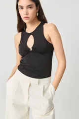 Musculosa negra de microfibra doble torsión sin mangas, con calce fit al cuerpo y largo hasta la cadera. Presenta un detalle de accesorio metálico con sustracción en el escote delantero.