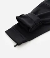 Pantalón deportivo de corte slim para hombre, confeccionado en poliéster color negro. Presenta cintura elástica con cordón de ajuste, bolsillos laterales y diseño ajustado en muslos y rodillas.