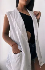 Chaleco blanco sin mangas con solapas y bolsillos frontales.
