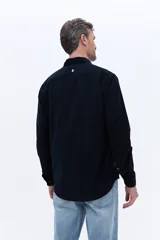 Camisa de pana de algodón con cuello clásico, cierre frontal de botones y mangas largas. Presenta un diseño de corte regular con textura suave y acabado mate.
