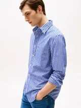 Camisa Tommy Hilfiger de hombre, de popelina de puro algodón con Flex Technology, con diseño de cuadros Vichy azules y blancos. Tiene cuello con botones, puños redondeados con botón, bolsillo de parche en el pecho y logo de Tommy Hilfiger bordado en el bolsillo.