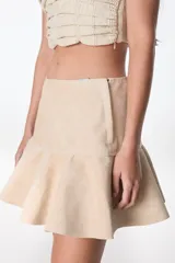 Minifalda color beige de cuero con volados en el ruedo.