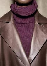 Jersey de punto de cuello alto, con diseño recto, aberturas laterales y manga larga con puños acanalados.