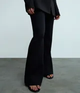Pantalón flare negro de punto roma con viscosa certificada, cintura incorporada y sin estampado.