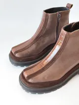Bota corta de cuero en tonos chocolate, con diseño de paneles texturizados y suela track robusta de goma.