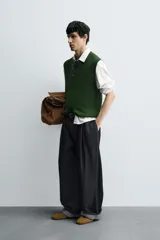 Chaleco de punto color verde oscuro, corte relajado (relaxed fit), con cuello redondo y sisas terminadas en rib.