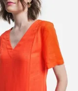 Vestido corto color naranja, de corte recto, con escote en pico y mangas cortas.