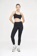 Top deportivo negro con tirantes finos regulables y banda elástica bajo el busto.