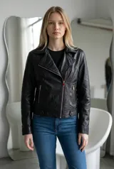 Campera estilo biker de ecocuero negro, con cierre frontal cruzado, solapas con broches y bolsillos laterales con cierre.