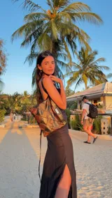 Vestido largo negro de lino, con breteles finos, espalda descubierta y tajo lateral. Presenta un volante de lino estampado en el escote.