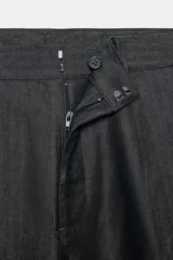 Pantalón de tiro medio confeccionado en mezcla de algodón, con diseño de corte recto y holgado. Presenta cintura con trabillas, cierre frontal con cremallera y botón, y bolsillos laterales ocultos en las costuras.
