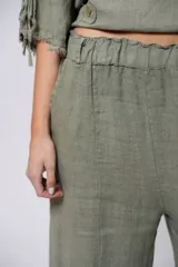 Pantalón verde oliva de lino, corte palazzo, con cintura elástica y aberturas laterales con botones.