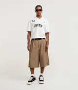 Bermuda masculina color beige, corte amplio, de viscosa y poliéster. Presenta cintura con trabillas, cierre tradicional y bolsillos laterales.